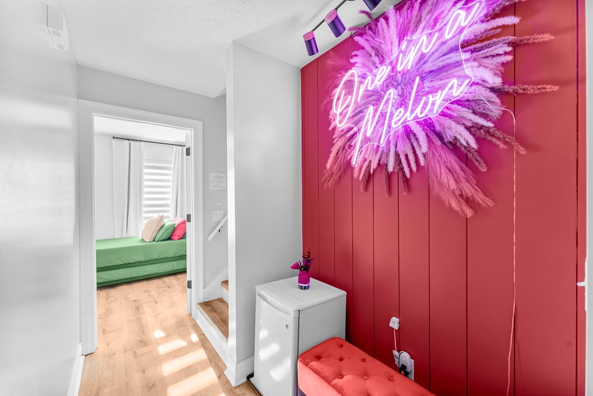 Passez par le couloir animé de « One in a Melon », avec un mini-réfrigérateur, un banc confortable et une décoration animée, le tout mis en évidence par un panneau de néon ludique. C'est l'endroit idéal pour prendre un verre ou une collation tout en vous imprégnant de l'atmosphère amusante de votre séjour !