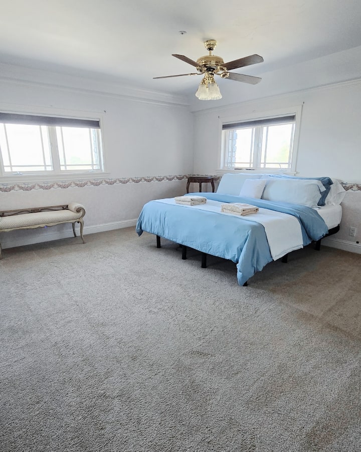 غرفة نوم في الطابق العلوي بسرير كبير بمقاس كبير وحمام عبر القاعة