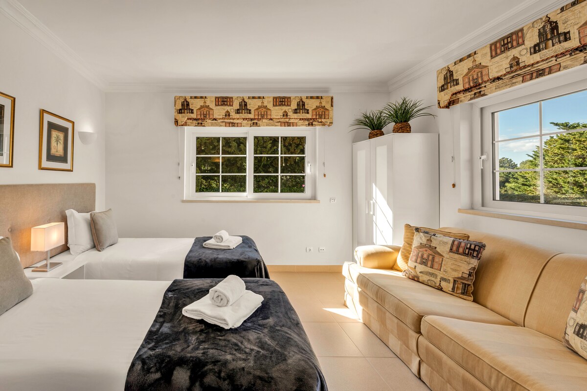 Suite 4: dos llits individuals, una decoració acollidora i un sofà per relaxar-se.