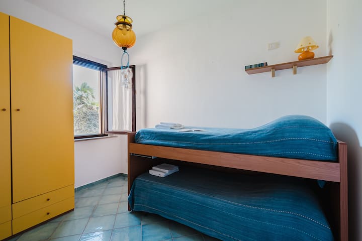 Dhomë fëmijësh, e ndriçuar, me një krevat të poshtëm me tërheqje dhe një dollap të madh