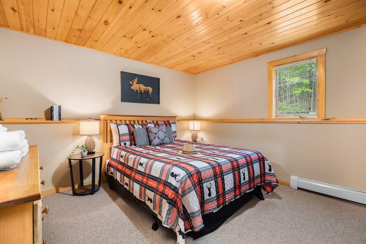 Basement Bedroom—Sleeps 4, featuring a plush queen bed and a twin-over-twin bunk with USB charging lamps.