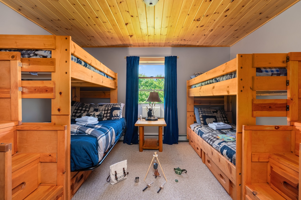 The upper bunk room boasts a comfortable arrangement of 4 beds that sleep a total of 5. 
