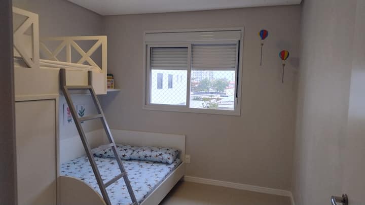 Chambre avec un lit double et un lit simple. Il dispose d'une armoire, de 3 oreillers et d'un ventilateur.  