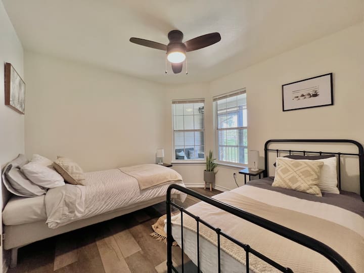 Dos camas individuales con almohadas, sábanas de estilo hotelero y edredones