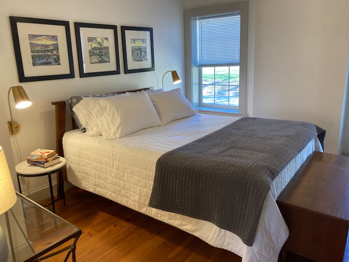 Este dormitorio junto a la sala de estar tiene una cama tamaño queen.