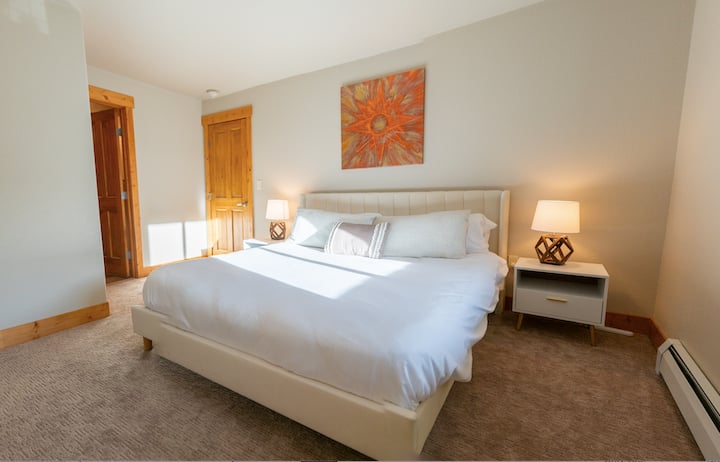 Chumba kikubwa cha kulala cha msingi kilicho na kitanda cha ukubwa wa mfalme na bafu la kujitegemea.