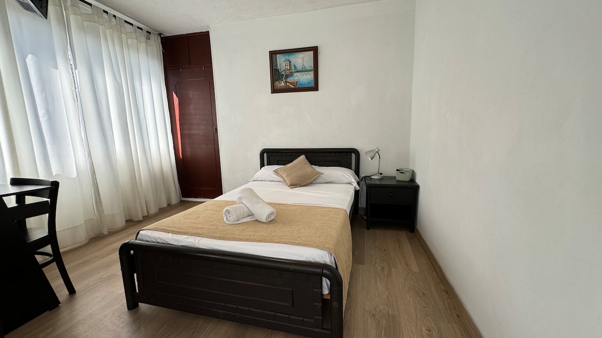 Mwangaza mzuri katika chumba kikuu, pamoja na taulo kwa ajili ya matumizi yako, meza ya kazi, televisheni ukutani, kwenye mlango wa nyuma unaoelekea bafuni kwenye chumba 