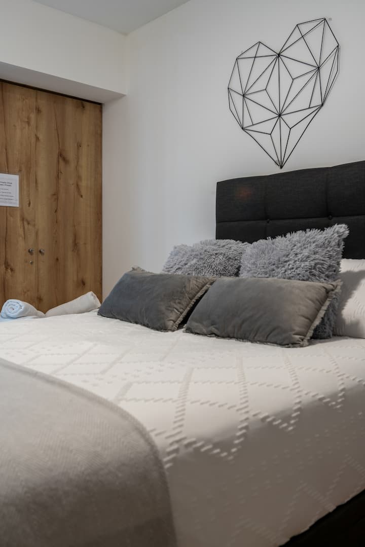 Chambre principale spacieuse et élégante, avec un grand lit Queen confortable. L'ambiance est soigneusement décorée pour offrir un havre de paix, walk in closet, tables de chevet. Parfait pour te détendre et te reposer. 