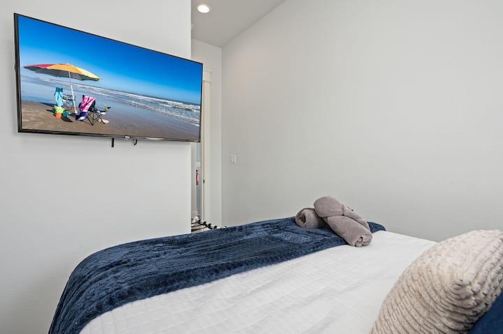 ห้องนอนนี้อยู่ถัดจากห้องนั่งเล่นและมีเตียงควีนไซส์โคมไฟพร้อมพอร์ตชาร์จที่วางกระเป๋าเดินทางและทีวี Roku  ใช้ข้อมูลเข้าสู่ระบบของคุณเองเพื่อรับชมแอพสตรีมมิ่งที่ชื่นชอบทั้งหมดได้