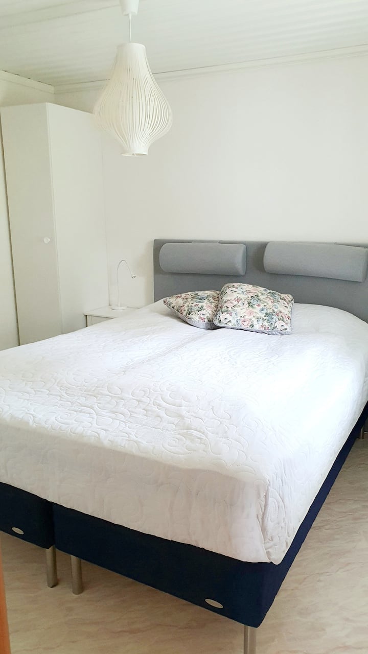 Double bed 160 cm with full mattress topper. 
A closet with four wire backs and place to hang shirts or blouses on hangers. 
Darkening roller blind. Bedside table with reading lamp on both sides of the bed.