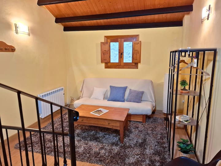 มุมสบายๆในห้องใต้หลังคาพร้อมโซฟาเบดและรายละเอียดการตกแต่งสไตล์ชนบท ที่พักที่สมบูรณ์แบบสำหรับการพักผ่อนอ่านหนังสือหรือเพลิดเพลินกับความอบอุ่นของเพดานไม้และแสงธรรมชาติที่ส่องเข้ามาทางหน้าต่าง