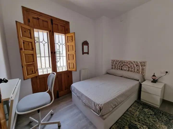 Amplio dormitorio con cama individual de 105 cm, un espacioso armario, sistema de calefacción eléctrica, ventanas de gran tamaño y un práctico escritorio para trabajar o estudiar en un ambiente acogedor y funcional.