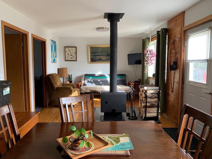 La sala de estar es espaciosa, tiene un televisor con transmisión Prime, una acogedora estufa de leña, futón y silla para niños perezosos, juegos y rompecabezas, y un montón de espacio para estirarse y disfrutar de tus propias aficiones.