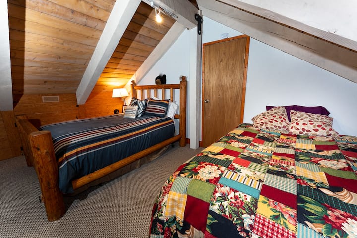 The third-floor bedroom features queen and full beds with Roku TV at the Forest Lodge near Silverwood Theme Park.