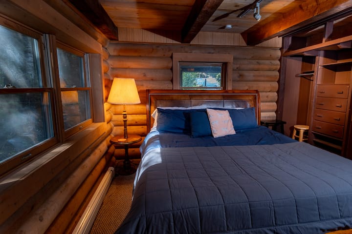This cozy middle-level bedroom features a king bed, spacious closet, and private sitting area with small TV at the Forest Lodge near Silverwood Theme Park.