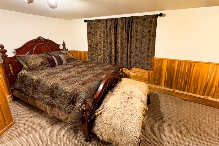 Spacious bottom-level bedroom featuring a king bed, private sitting area, and ample closet space for your stay at the Forest Lodge near Silverwood Theme Park.