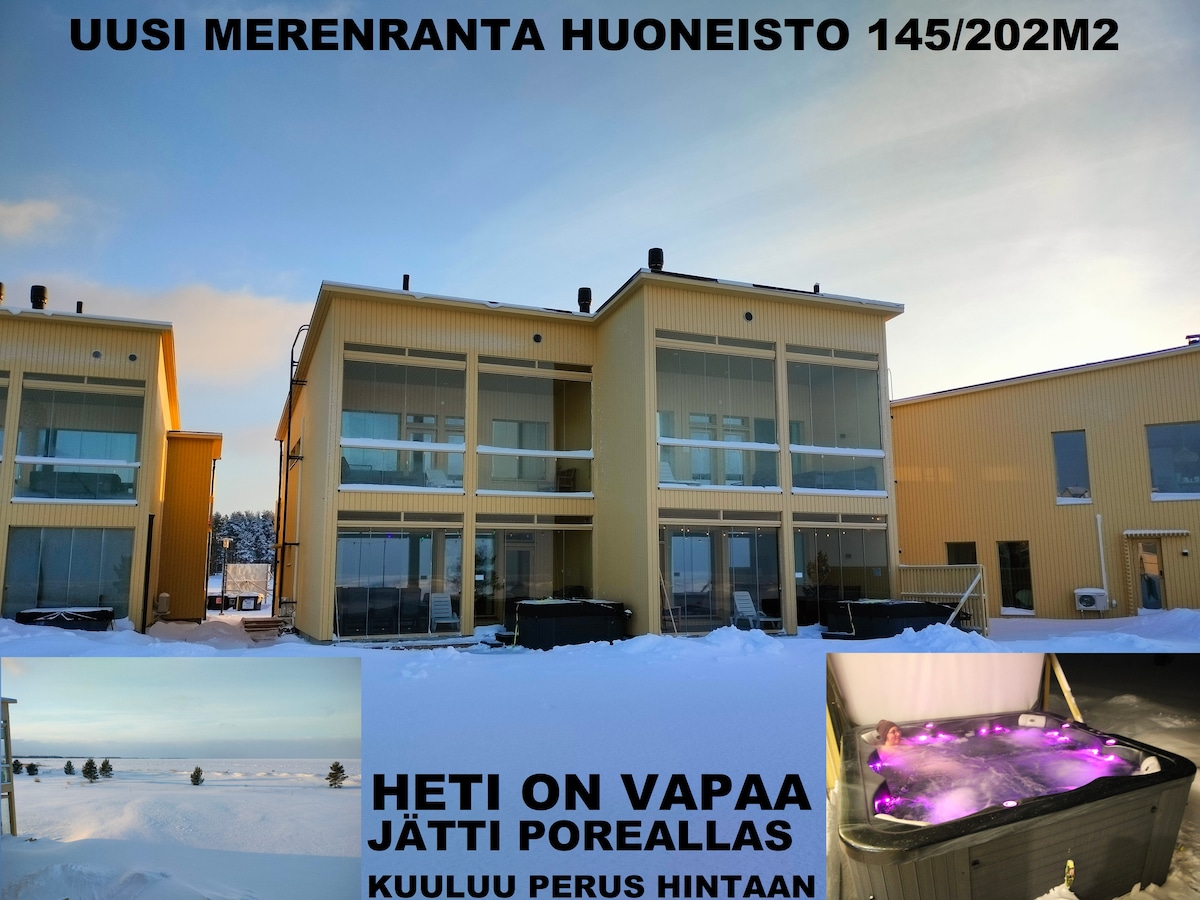 A newly built beachfront apartment is presented, featuring a two-story structure with large glass doors for natural light. Snow covers the ground, emphasizing the building's modern design and spacious exterior. A hot tub is visible in the corner, surrounded by soft purple lighting.