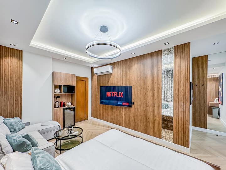 Dhomë gjumi shumë e madhe me një krevat dopio "king-size", divan, televizor të madh dhe një kuzhinë me aparat kafeje dhe ibrik çaji 