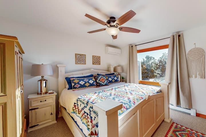 เตียงคิงไซส์ขนาดใหญ่ในห้องนอน 2 พร้อมวิวที่สวยงามไปยัง Pinon pines, juniper และยอดเขา Sandia ที่อยู่เลยเชิงเขาไป