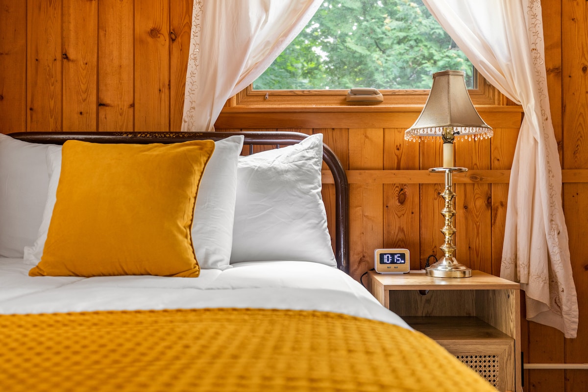 Оваа спална соба има удобен полн кревет, плакар, гардеробер и ноќно шкафче со порти за полнење. Со топла дрвена ламперија и мека кадифена постелнина, овој шармантен простор нуди мирно прибежиште далеку од вревата на денот.