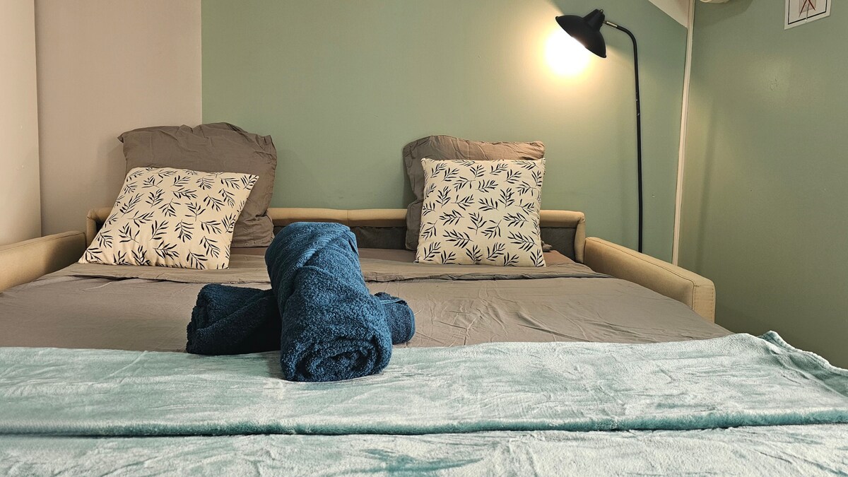 Дневната соба со кауч на спуштање зрачи со релаксирачка атмосфера со ламба за читање идеална за релаксација. Просторот нуди мирна атмосфера, совршена за релаксирачки крај на денот.