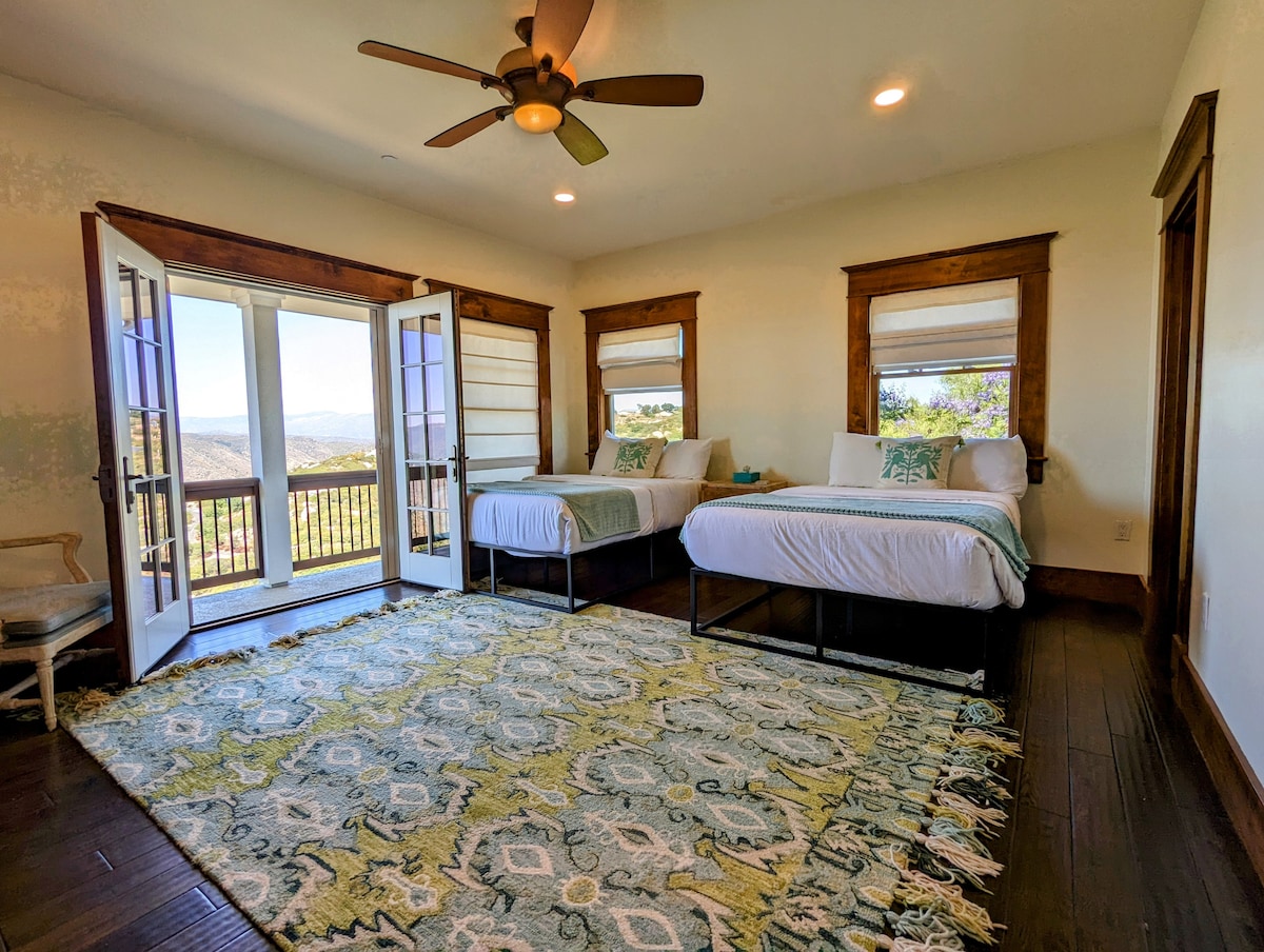 Main house second bedroom with 2 full beds, en-suite full bathroom, closet, and balcony