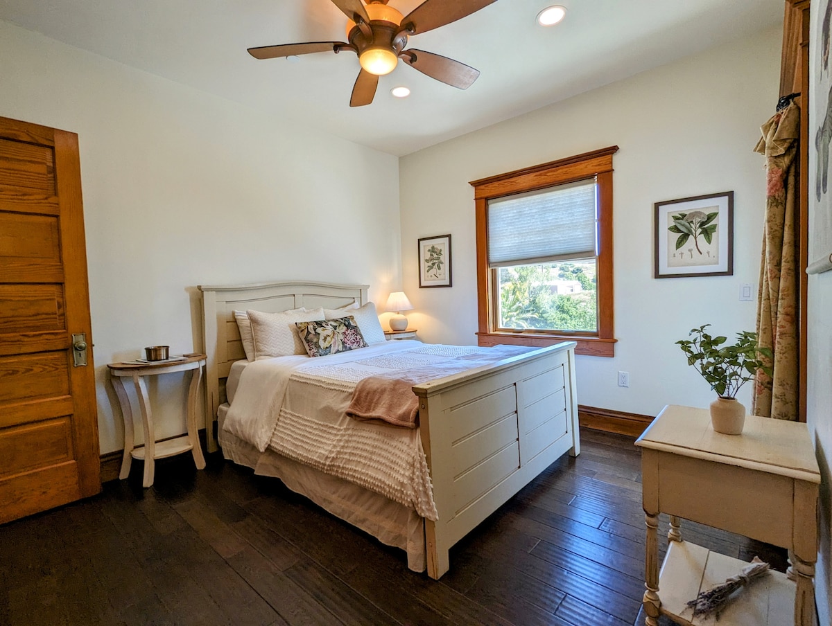 Main house third bedroom with queen bed, en-suite full bathroom, closet, and balcony