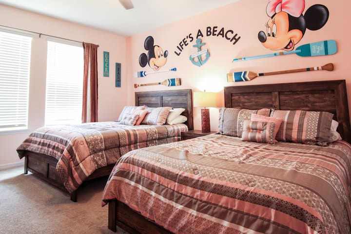Გაატარეთ სასიამოვნო და მყუდრო საცხოვრებელი ამ პლაჟზე, მიკი და მინი საძინებელში! Ეს ოთახი იდეალურია ორი კომფორტული ორადგილიანი საწოლით, რბილი პასტელის ტონებით, საზღვაო დეკორითა და თქვენი საყვარელი დისნეის დუეტის მომხიბლავი კედლის ხელოვნებით, ეს ოთახი იდეალურია ბავშვებისთვის ან ოჯახებისთვის, რომლებსაც დასვენება სურთ   