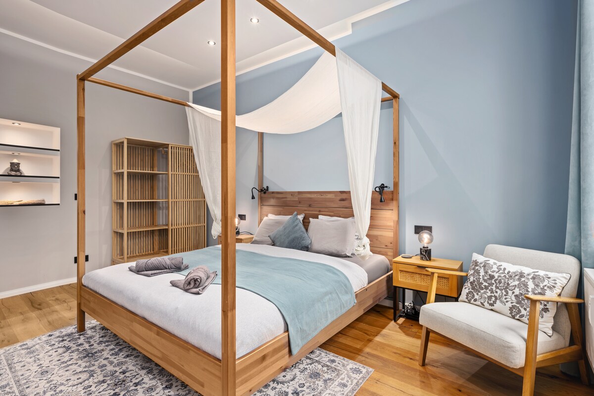 Lit à baldaquin avec fauteuil dans la zone de couchage