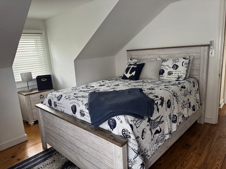 Cama queen, TV en streaming, unidad de ventana de aire acondicionado, ventilador de techo.