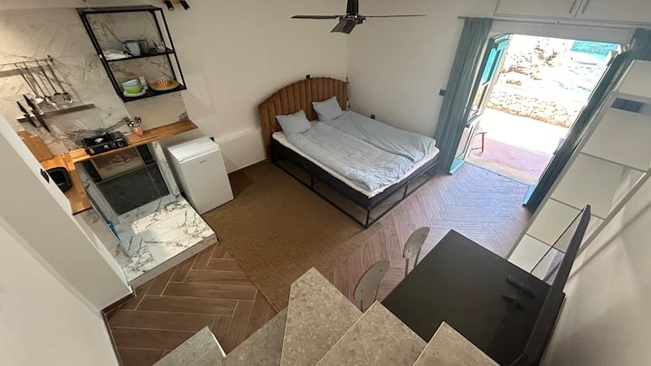 The cozy and functional Bedroom 2 which also has its own kitchenette. Take your coffee right out and sip at the edge of the sea!

Here you can also see the steep stairs that wind their way through the house. 