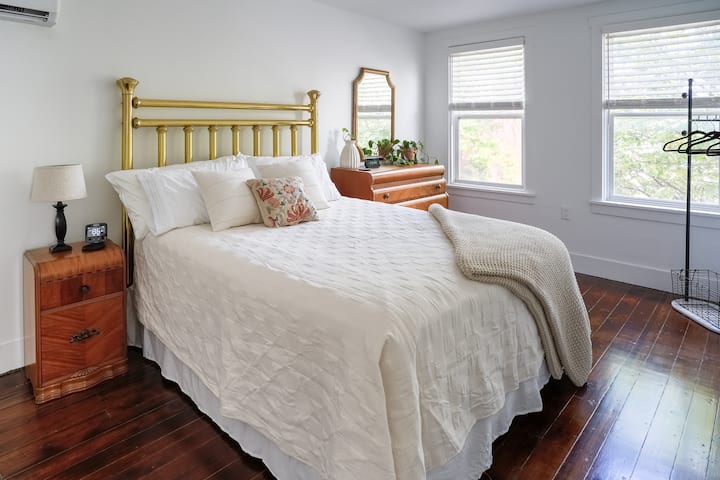 Descansa con estilo en este encantador dormitorio recientemente renovado con una cama de latón tamaño queen, ropa de cama de tonos neutros y hermosos pisos de madera. La habitación también incluye una cómoda y un perchero, que proporciona mucho espacio de almacenamiento para una estancia cómoda.