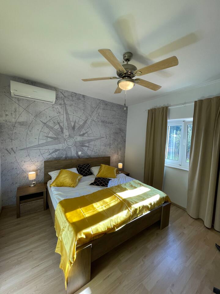 Udobna potpuno nova spavaća soba s klima-uređajem i motivom vjetrenjače na zidu. 