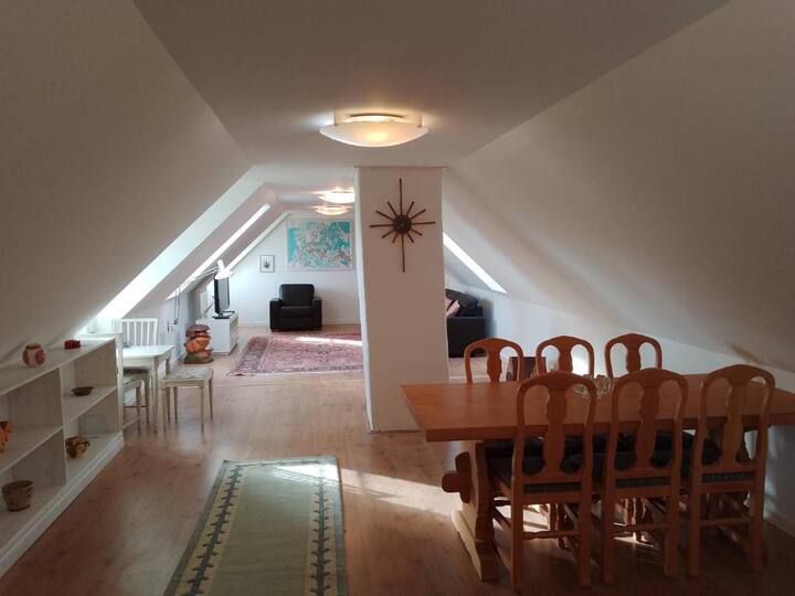 Sebule kubwa ya ghorofa iliyo na televisheni na meza ya kulia chakula/michezo ya kubahatisha 