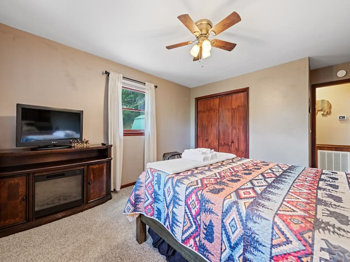 غرفة نوم ثانية بسرير كوين مع تلفزيون ذكي 65بوصة ومدفأة كهربائية