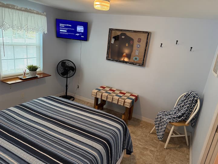 Our Fireman themed Queen Bedroom; offers a comfy Nectar Queen bed, Roku TV, levoit air purifier, oscillating fan, authentic fire hose luggage rack, two night stands with two lamps, two extra charging outlets, chair and blanket.