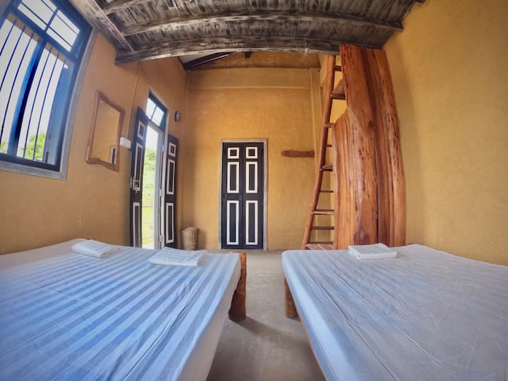 Habitación 2: incluye una cama doble y una cama individual en la planta principal, además de una cama doble adicional en el ático.