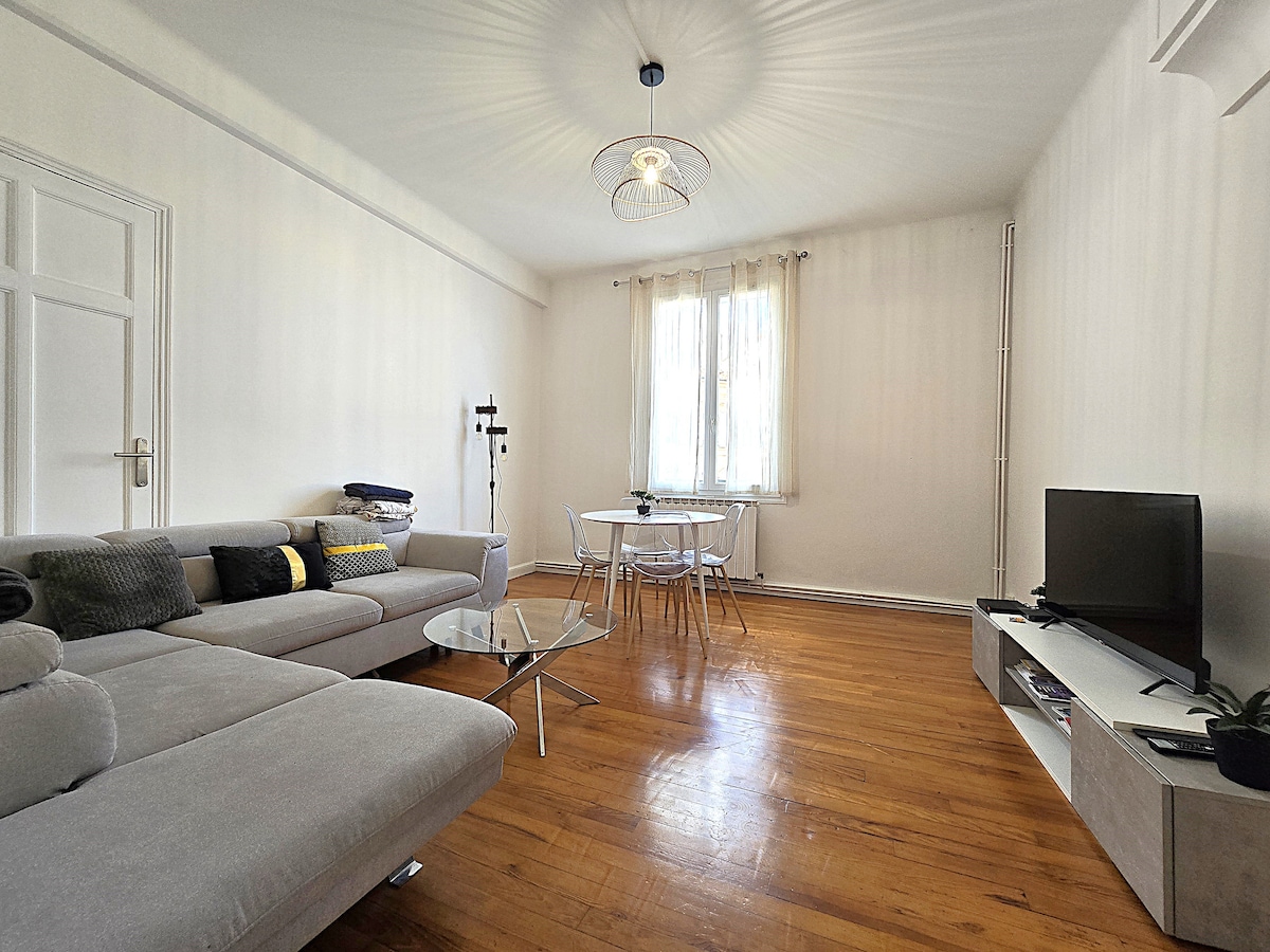 Sala de estar con sofá espacioso y convertible, mesa y sillas, TV y fibra de Internet.