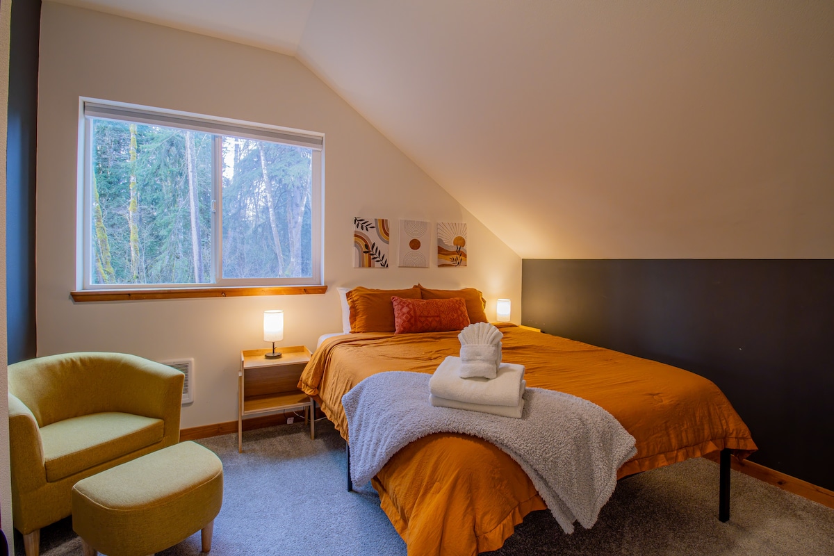 The Orange room has a queen sized bed, large closet, luggage rack and a comfortable chair to lounge in!