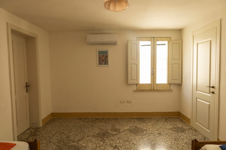 غرفة نوم بسريرين مع شبكة عظمية وطاولات وشماعات بجانب السرير ومكيف هواء بمناخ 9000 وحدة حرارية بريطانية ونافذة في الفناء الداخلي (واي فاي مع إشارة قوية موجودة في جميع أنحاء الشقة).