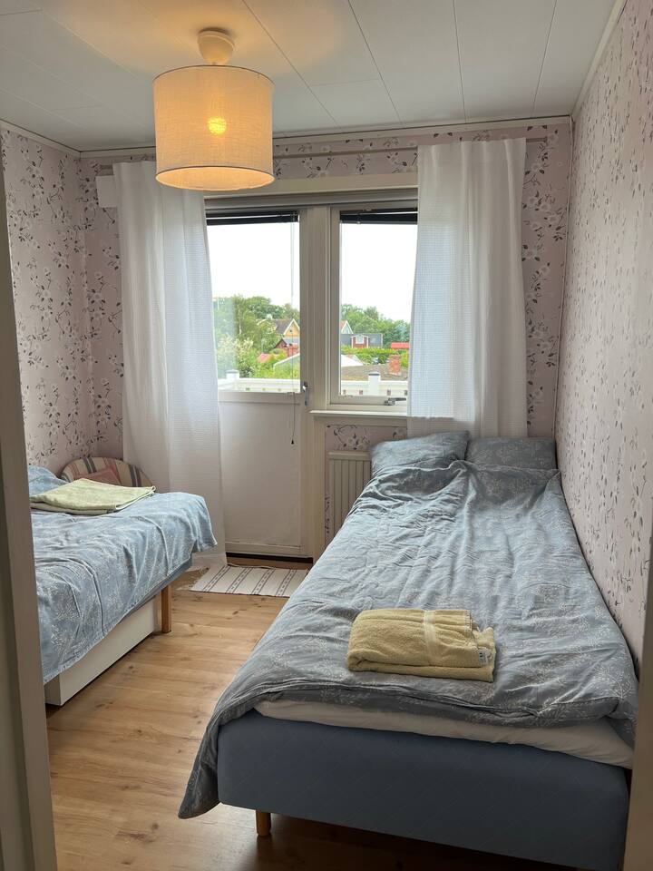 Chumba cha kulala cha pili chenye vitanda viwili vya sentimita 90 na njia ya kutoka kwenye roshani kubwa.