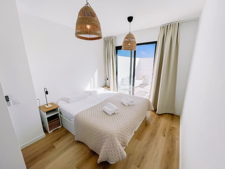 Upstairs bedroom with King Size bed (180x200) / can be put as 2 single beds. Bedroom with bathroom ensuite leading to large terrace with loungers and sunbeds.