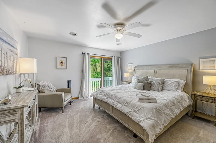 Second-floor master with king bed, balcony, full ensuite bath with tub and shower, and walk-in closet.