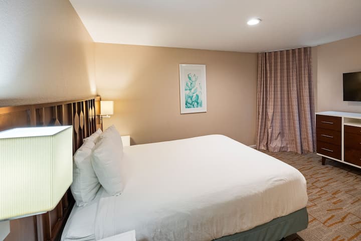 El primer dormitorio ofrece un amplio espacio y una acogedora cama tamaño queen, ideal para relajarse después de un día de exploración.