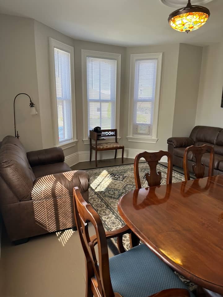 Il primo piano presenta un soggiorno e una sala da pranzo combinati.  La sala da pranzo può ospitare fino a sei persone.  Ci sono un divano letto, un divanetto e una TV montata a parete. 