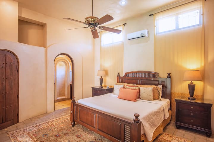 Ingia katika ulimwengu wa starehe kupitia mpangilio huu wa chumba cha kulala kinachovutia. Kitanda cha ukarimu na feni ya dari yenye kutuliza huunda mazingira bora kwa usiku wenye utulivu na asubuhi yenye utulivu.