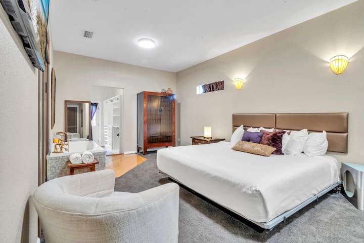 Голямо двойно легло и хидромасажна вана в просторната спалня.