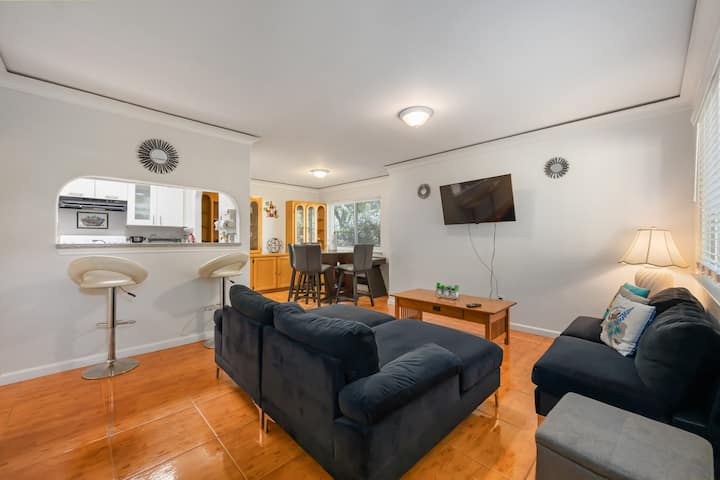 Relájate en el acogedor salón con TV de pantalla plana y fácil acceso a las áreas de comedor y cocina.