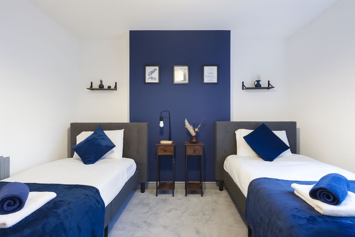 卧室配备两张单人床，提供干净的床上用品和毛巾，打造舒适的休憩场所。 它还包括一个带衣架的衣架架，以及一张桌子和椅子，非常适合用作书桌。
