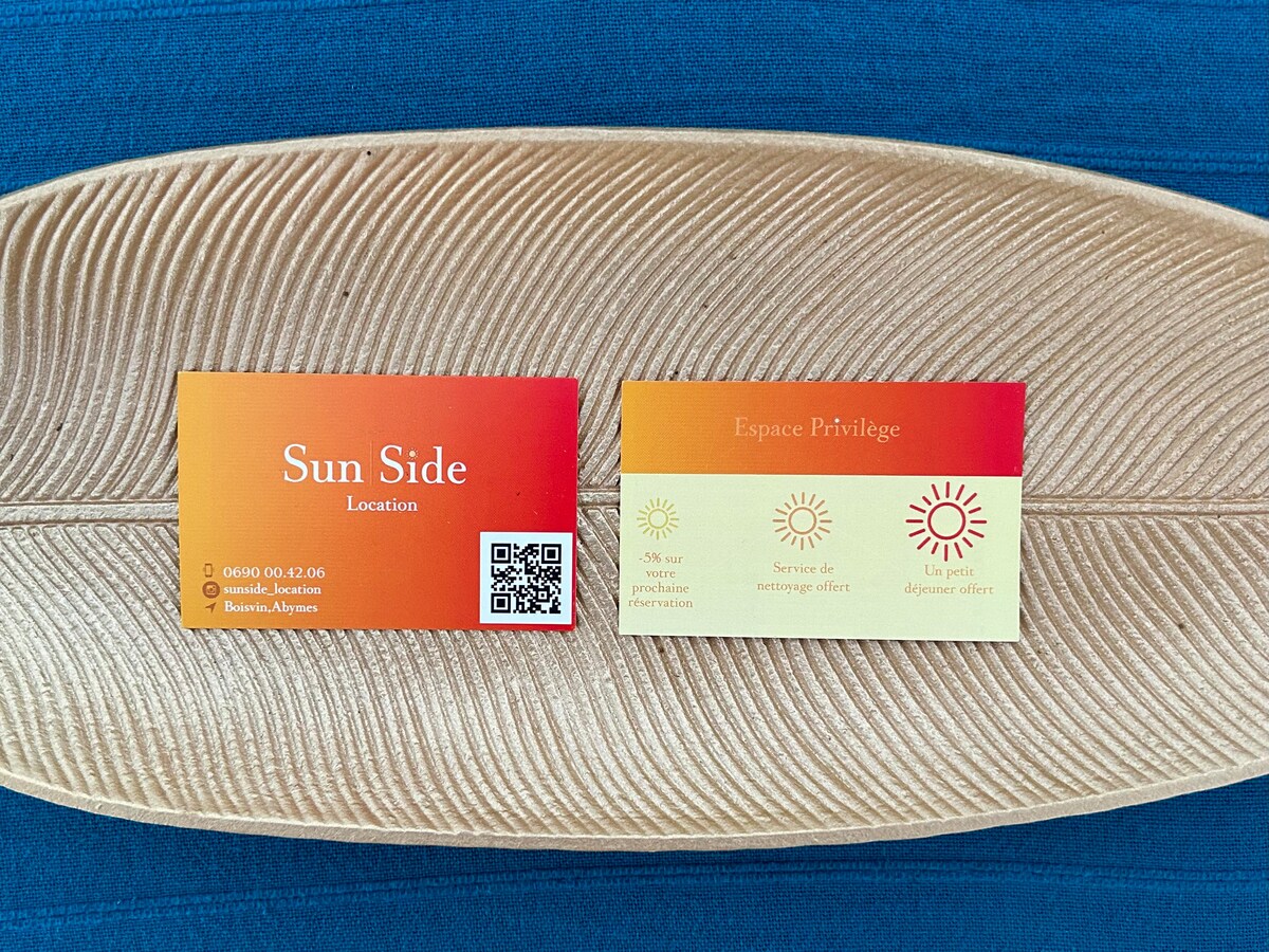 Two business cards are displayed on a textured, leaf-shaped platter. One card features the name 'Sun Side' along with a QR code, while the other card is labeled 'Espace Privilège,' indicating various services. The cards are designed with a gradient of warm colors.